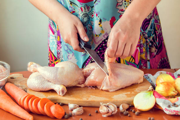 istock Woman chopping raw chicken for cooking in kitchen 836658194