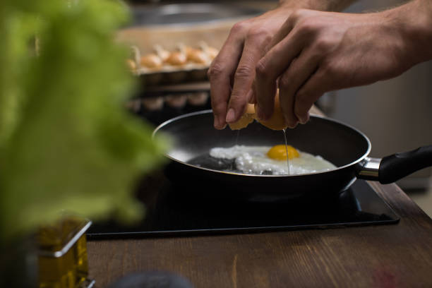 istock partial view of young man preparing eggs for breakfast in kitchen at home 836660542