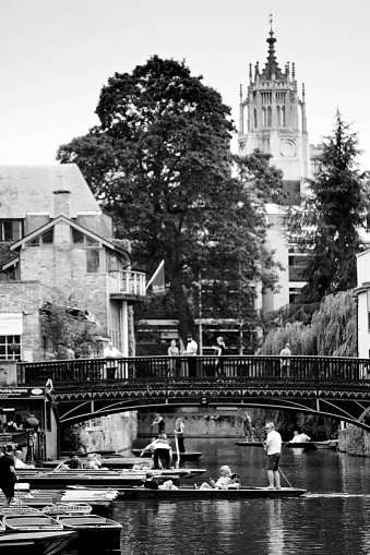 A group of tourists hiring punts and either returning or leaving with their punts from Scudamore's punt hire company on the River Cam in Cambridge, England. Cambridge is famous for punts and is one of the two premiere University towns in the UK.