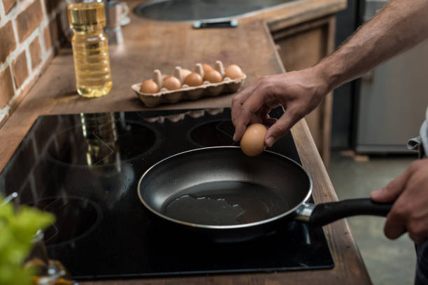 istock partial view of young man preparing eggs for breakfast in kitchen at home 836661878