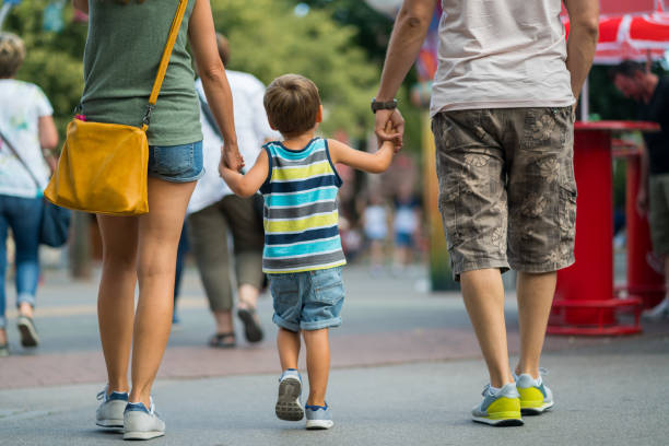 rear view family walking together on summer day in amusement park - prater park imagens e fotografias de stock