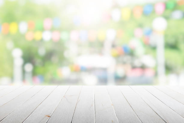 Empty wooden table with party in garden background blurred.