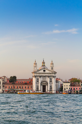 Santa Maria del Rosario (St. Mary of the Rosary), or simply I Gesuati, is an 18th-century church on the Giudecca canal in Venice, Italy. The image taken at sunset with blue canal water in foreground and clear blue sky in background.