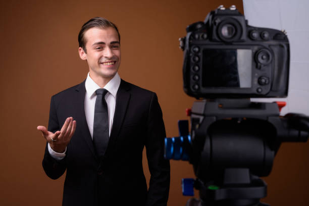 istock Studio shot of young businessman vlogging against colored background 836672616