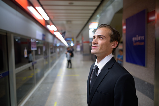 Portrait of young businessman inside the MRT subway train station in Bangkok Thailand horizontal shot