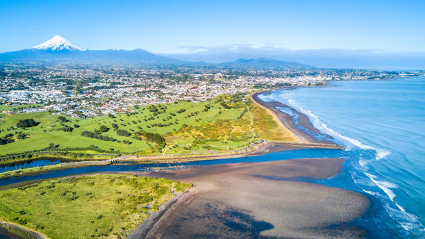 Aerial view on Taranaki coastline with a small river and New Plymouth on the background. Taranaki region, New Zealand New Plymouth, Taranaki region, New Zealand dormant volcano stock pictures, royalty-free photos & images