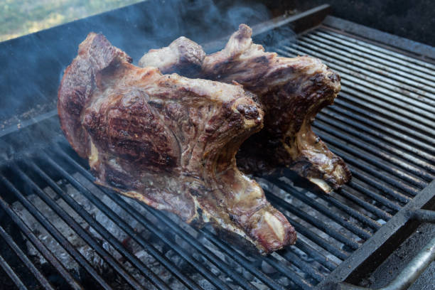 istock two T-bone steak cooking on an open flame grill , with rosemary and salt 836684246