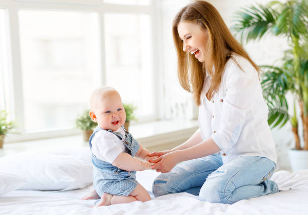 istock Happy laughing mother and baby playing in bed 836684706