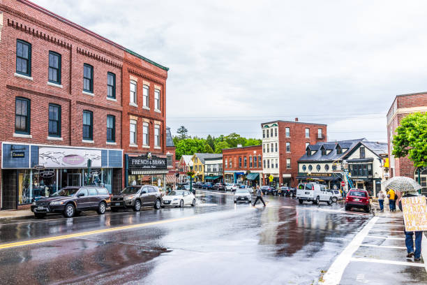 śródmiejska mała wioska w maine podczas deszczu z osobą chodzącąą z znakiem roller derby - town maine american culture camden maine zdjęcia i obrazy z banku zdjęć