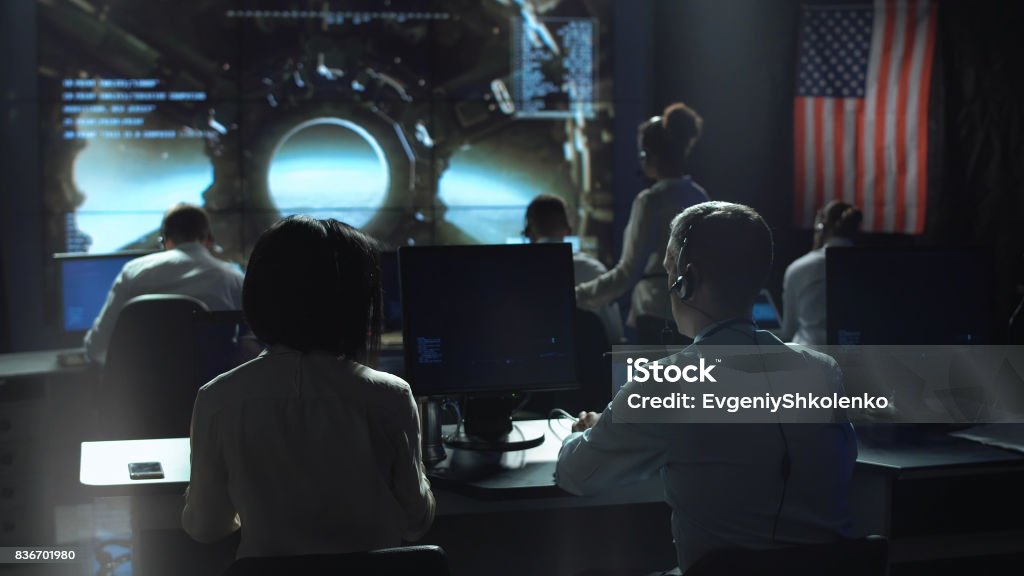 Personas que trabajan en el centro de control de misión - Foto de stock de Control de Misión libre de derechos