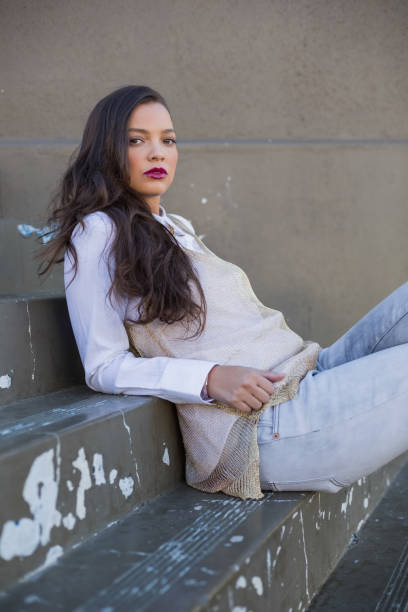 istock Attractive brunette with red lips leaning on stairs 836704146