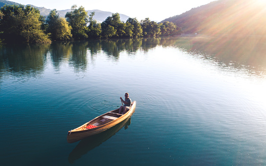 High angle shot of a man enjoying canoeing on the lake.