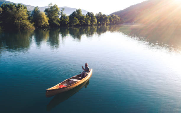 Perfect combination of nature and sport High angle shot of a man enjoying canoeing on the lake. rowing boat fishing stock pictures, royalty-free photos & images
