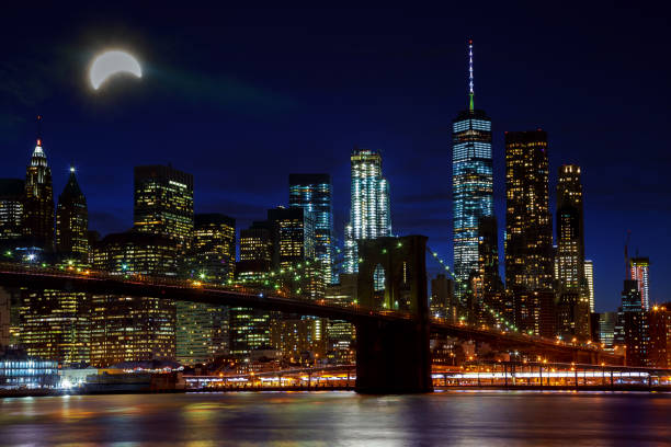 istock Solar eclipse, New York NY august 21 2017 New York City's Brooklyn Bridge and Manhattan skyline illuminated 836728246