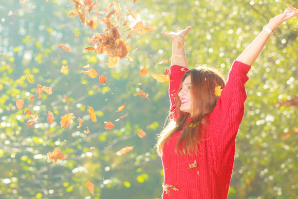 istock Playful woman outdoors playing with leaves. 836729446