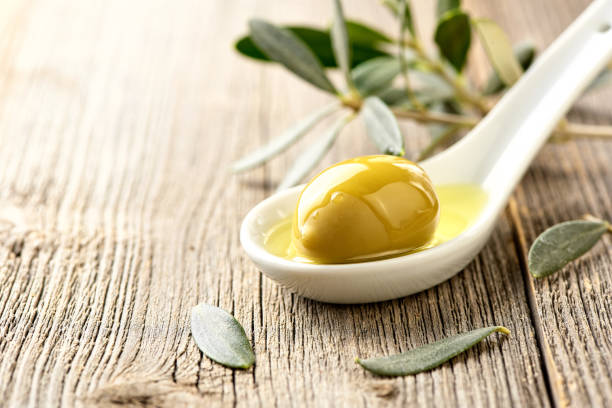 istock Olives, olive oil and olive branch on wooden light table with copy space for design. 836754492
