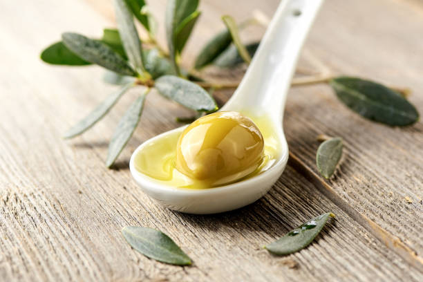 istock Olives, olive oil and olive branch on wooden light table. 836754680