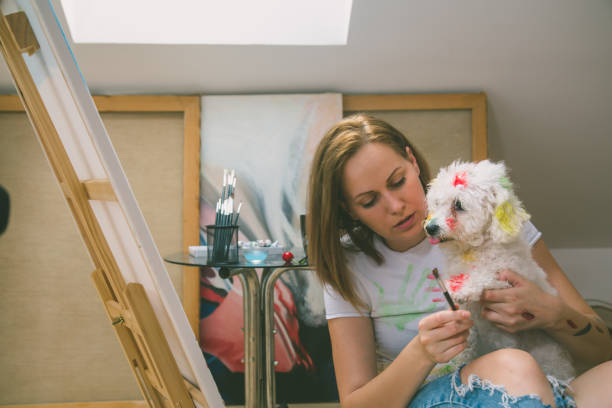 istock Happy young woman paints on canvas 836781608