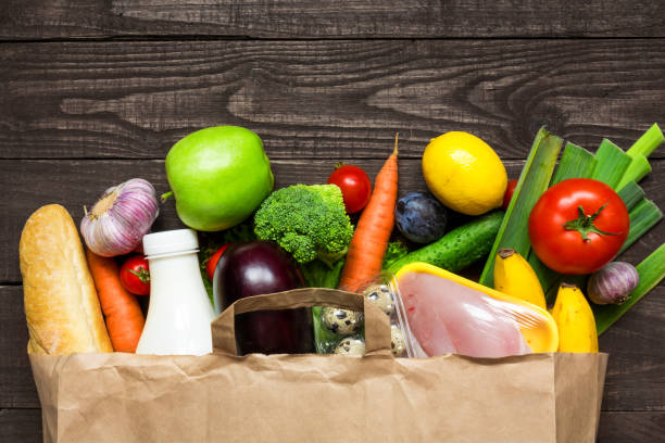 bolsa de papel completo de diferentes alimentos de salud sobre fondo de madera rústico - milk bread fotografías e imágenes de stock