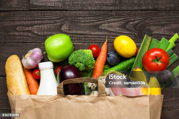 Photo libre de droit de Sac En Papier Pleine De Différents Aliments De Santé Sur Fond En Bois Rustique banque d'images et plus d'images libres de droit de Légume