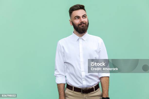 Flying Of Thoughts Thoughtful Bearded Businessman Looking Away While Standing Against Light Green Wall Studio Shot Stock Photo - Download Image Now