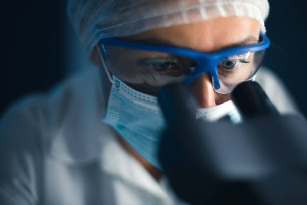 Looking into a microscope Cropped shot of a young female scientist looking into a microscope. biochemistry stock pictures, royalty-free photos & images