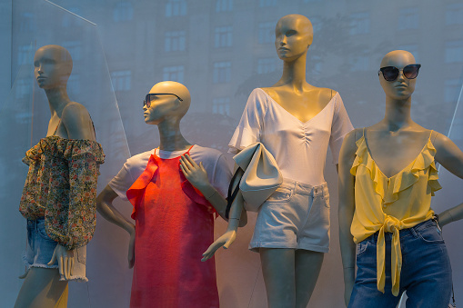 Mannequins in a shop window and a reflection of the city