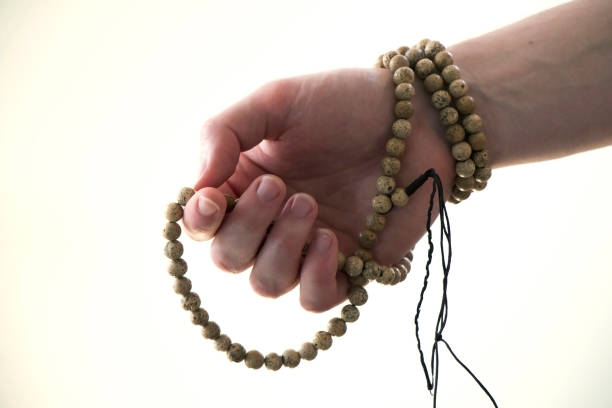 istock Hand holding white wooden buddhist bracelet on white background. 836852948