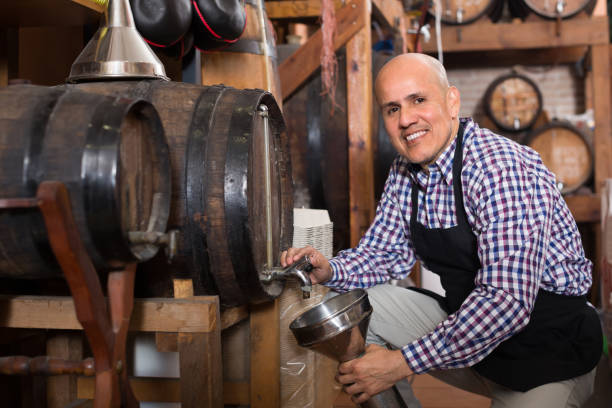 istock Seller pouring wine from wood barrel 836888256