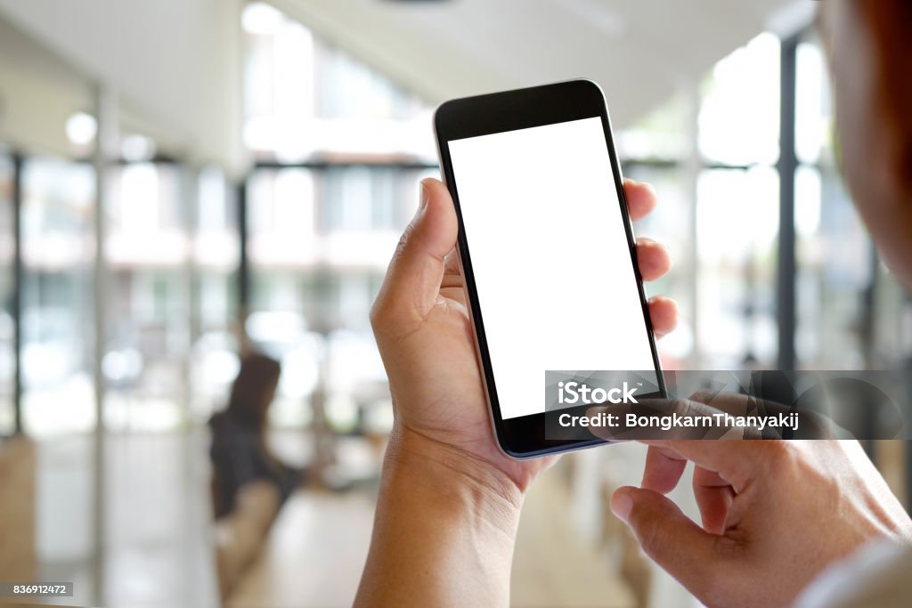 Man hands holding blank screen a smartphone and blurred background. Telephone Stock Photo