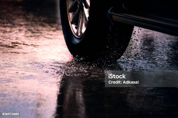 Motion Car In Rain Big Puddle With Water Splashing From The Wheels Stock Photo - Download Image Now