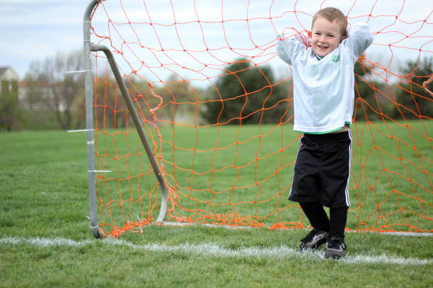 istock Boy in Soccer Goal Net 836928476