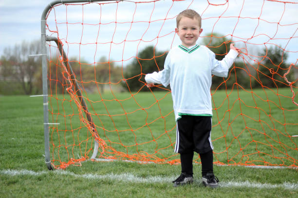istock Boy in Soccer Goal Net 836928478