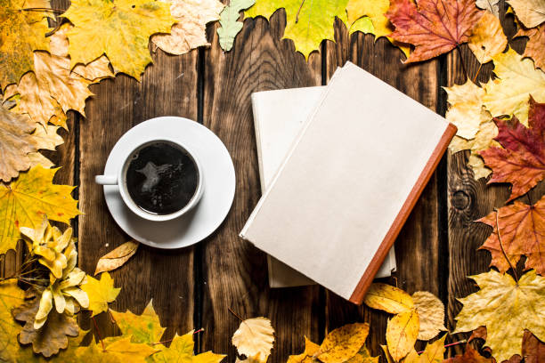 istock Cup of coffee with an old book and maple leaves. 836991076