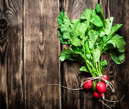 Organic food. Bunch of fresh radishes. On wooden background.