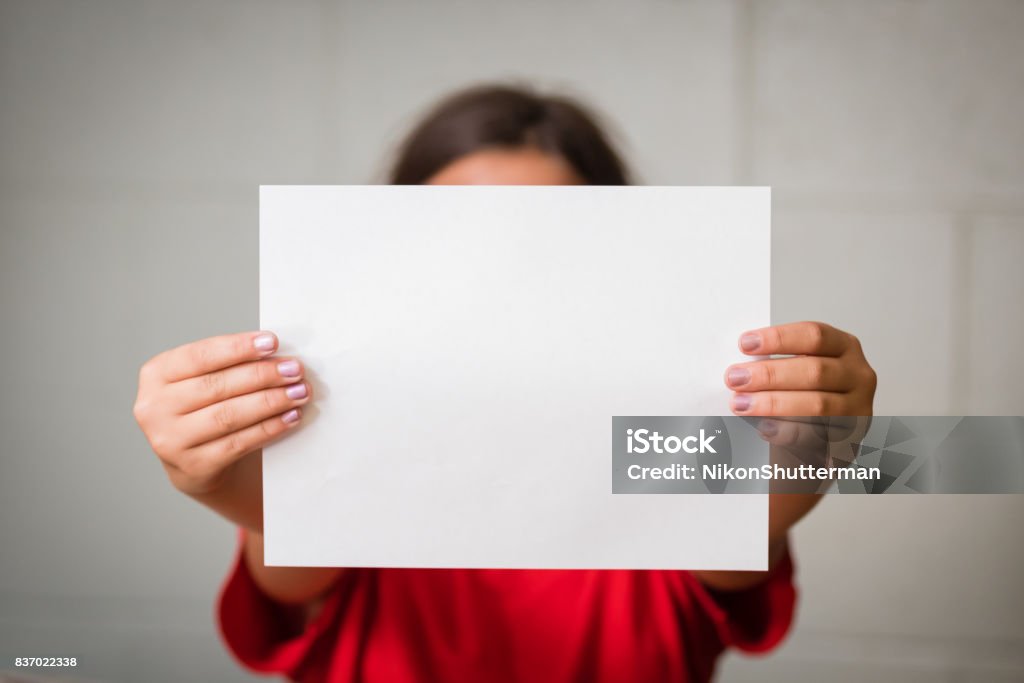 Girl with Blank Paper A girl holding up a blank paper Holding Stock Photo