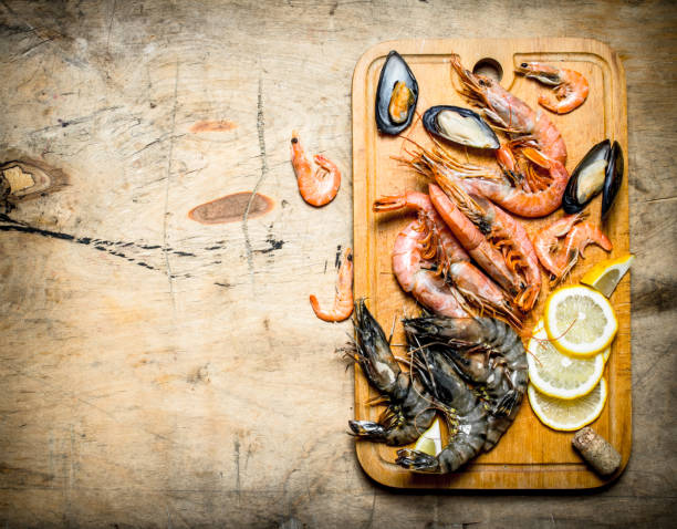 istock Fresh seafood. Cutting Board with shrimp, shellfish and lemon. 837029354