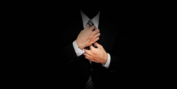istock Businessman in black suit on panoramic black background 837036774
