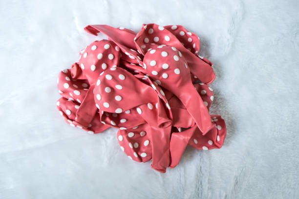 istock Deflated red pastel with white dots rubber air balloon isolated over the white background 837067738