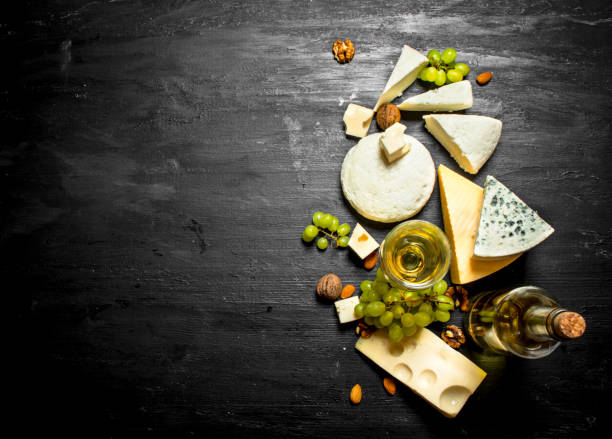 bicchiere di vino bianco con diversi formaggi, uva e noci. - cork tops foto e immagini stock