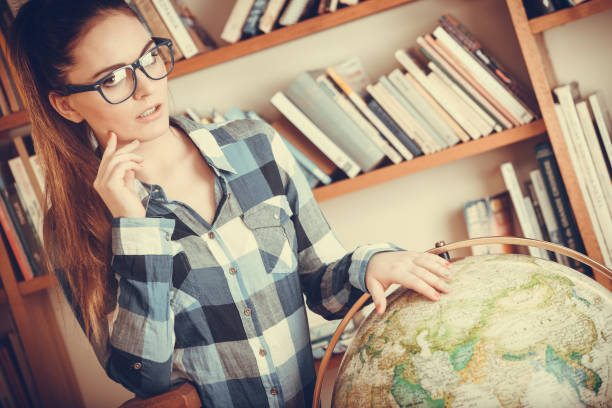 istock Hipster girl in library working with globe 837099792