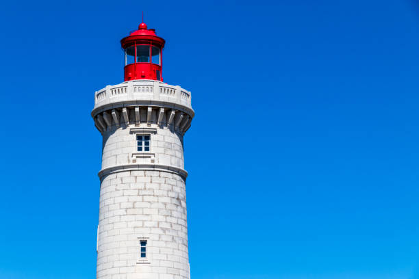Close-up view of the Phare du Mole Saint-Louis, a white and red lighthouse in Sete, Southern France