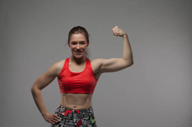 istock Happy strong woman showing biceps, studio shot 837117832