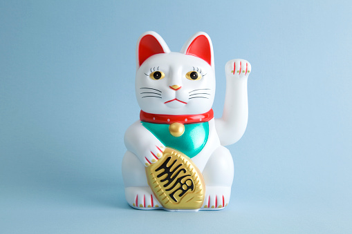 a Maneki-neko plastic cat, Symbolizing luck and wealth, on a pop and colorful background.\