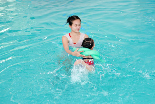istock Mother with baby in swimming pool training. 837151168