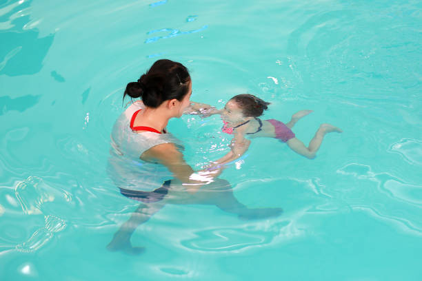 istock Close up mother teaching kid in swimming pool. 837159606
