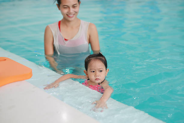 istock Close up mother teaching kid in swimming pool. 837159862