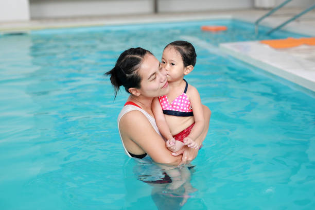 istock Close up mother teaching kid in swimming pool. 837164314