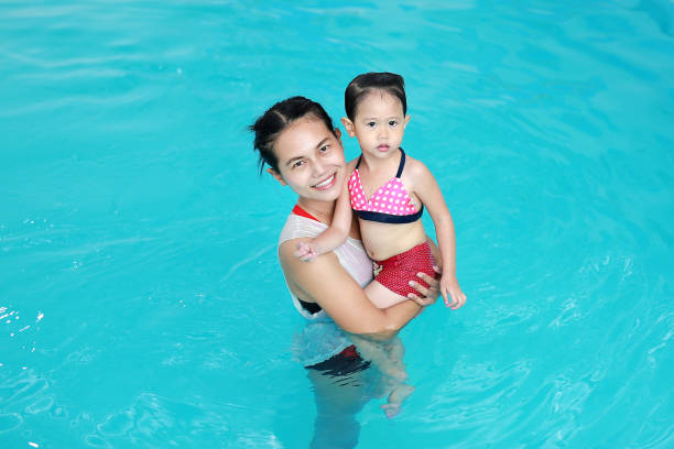 istock Close up mother teaching kid in swimming pool. 837164846