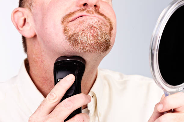 istock Bearded man shaving neck area with electric razor 837167522